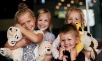 Glade børn med bamser smiler og krammer